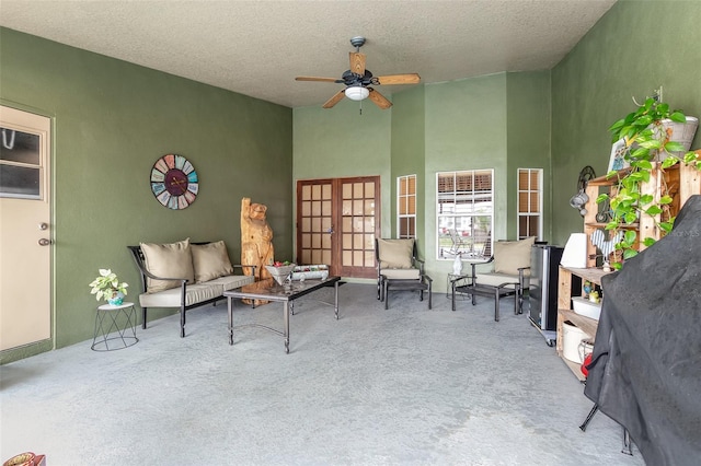 interior space with french doors, a textured ceiling, light colored carpet, and ceiling fan