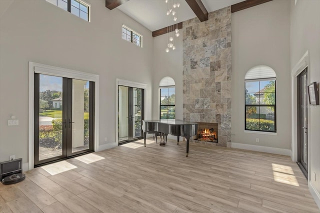 interior space featuring a healthy amount of sunlight, light hardwood / wood-style flooring, and beamed ceiling