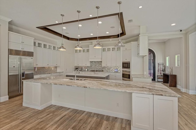 kitchen with appliances with stainless steel finishes, white cabinetry, and a large island with sink