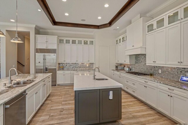 kitchen with a center island with sink, tasteful backsplash, sink, and stainless steel appliances