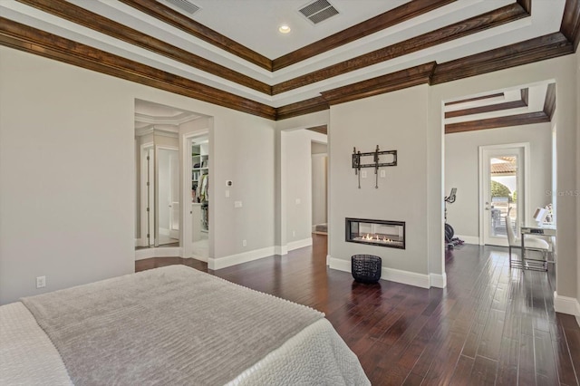 bedroom with a raised ceiling, dark hardwood / wood-style floors, and ornamental molding