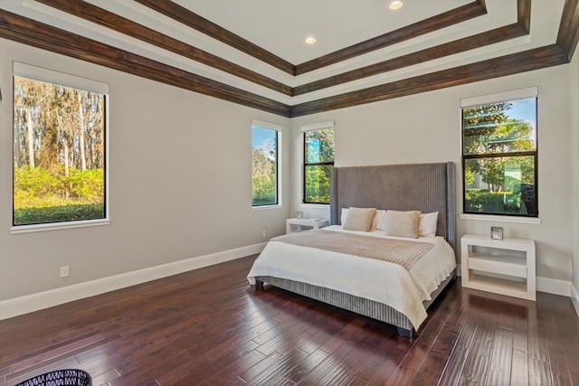 bedroom with a tray ceiling, dark hardwood / wood-style flooring, and ornamental molding