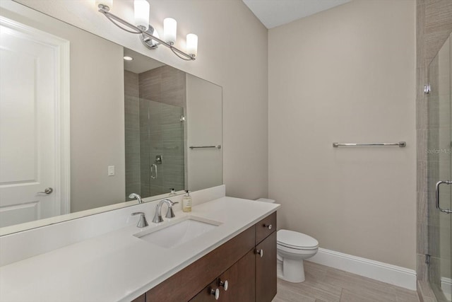 bathroom with tile floors, oversized vanity, a shower with shower door, and toilet