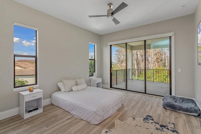 bedroom with light wood-type flooring, ceiling fan, and multiple windows