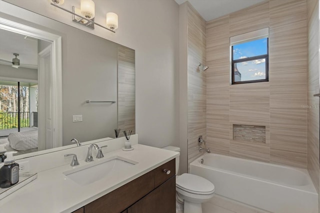 full bathroom featuring large vanity, toilet, and tiled shower / bath