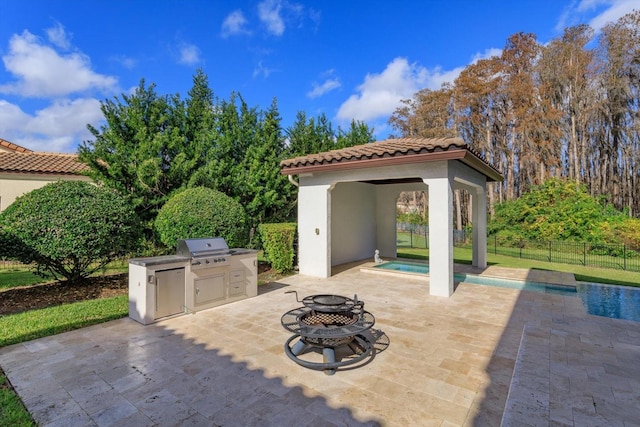 view of patio / terrace featuring a gazebo, a fire pit, exterior kitchen, area for grilling, and a fenced in pool