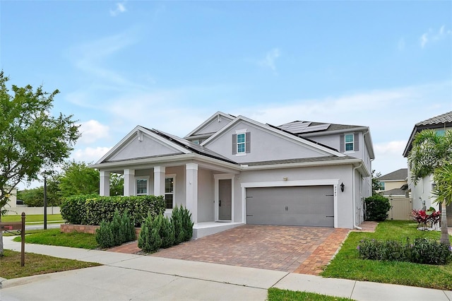 view of front of house featuring a front lawn, a garage, and solar panels