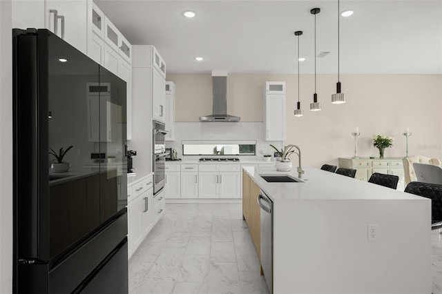 kitchen featuring pendant lighting, light tile floors, wall chimney range hood, white cabinets, and sink