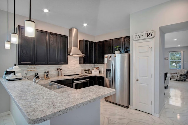 kitchen featuring hanging light fixtures, stainless steel appliances, kitchen peninsula, wall chimney exhaust hood, and sink