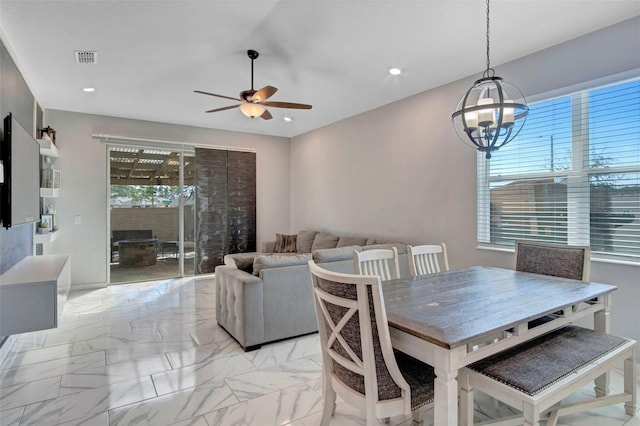 dining space with light tile floors and ceiling fan with notable chandelier