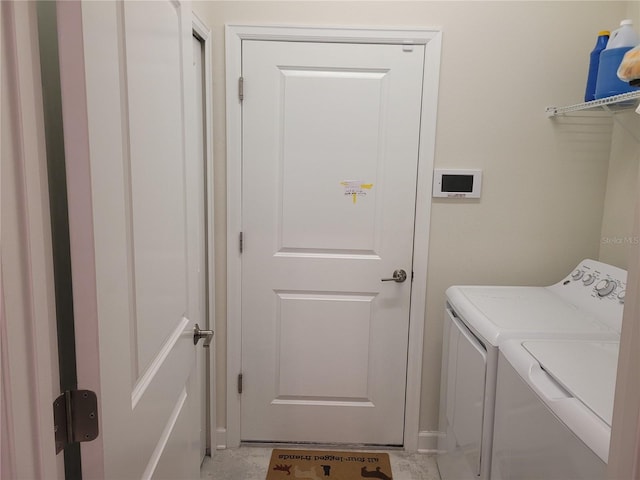 washroom with washer and clothes dryer and light tile floors