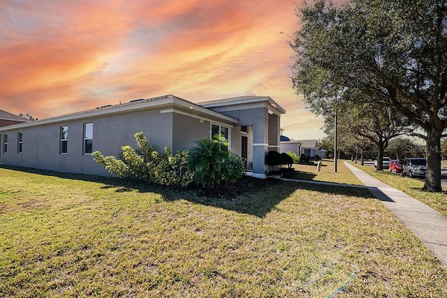 property exterior at dusk with a lawn