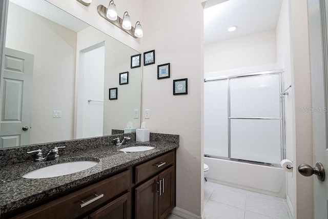 full bathroom with tile patterned floors, vanity, enclosed tub / shower combo, and toilet