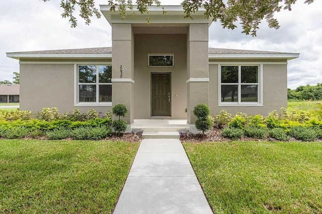 entrance to property featuring a lawn