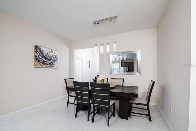 dining area featuring light tile patterned floors and a textured ceiling