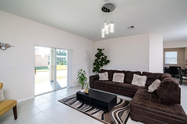 tiled living room with a chandelier and a textured ceiling