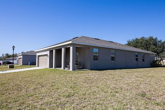 view of side of property featuring a garage and a yard