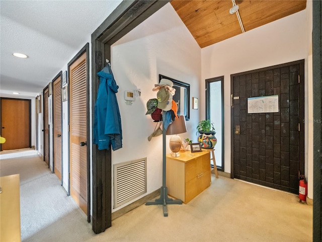 interior space featuring a textured ceiling, wooden ceiling, and lofted ceiling