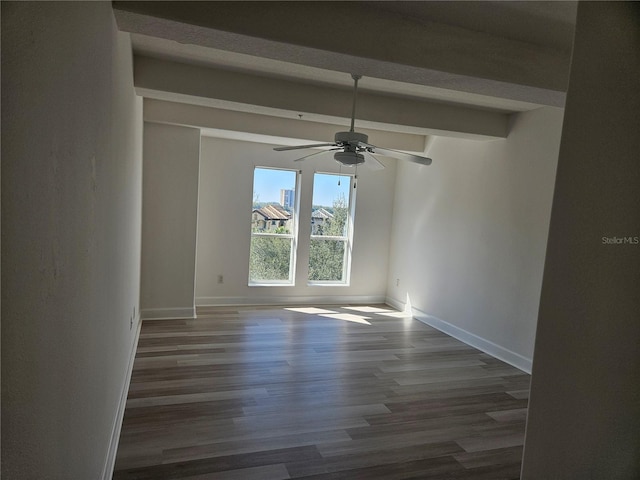 empty room with ceiling fan, dark hardwood / wood-style floors, and beamed ceiling