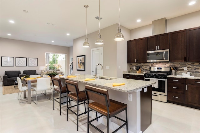 kitchen with light tile floors, appliances with stainless steel finishes, a breakfast bar, and sink