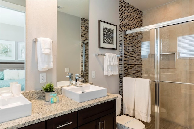 bathroom featuring toilet, large vanity, and walk in shower