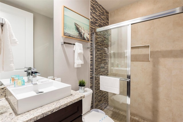 bathroom featuring walk in shower, toilet, and vanity