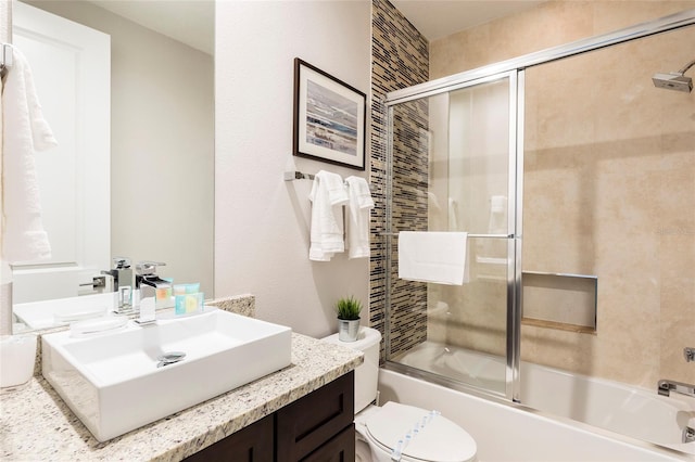 full bathroom with toilet, vanity, and bath / shower combo with glass door