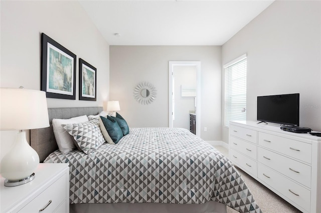 carpeted bedroom featuring ensuite bath