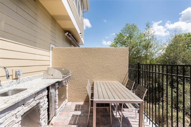 balcony featuring area for grilling, a grill, a patio area, and sink