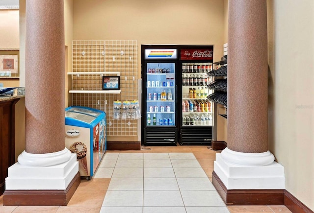 interior space featuring decorative columns and light tile patterned flooring