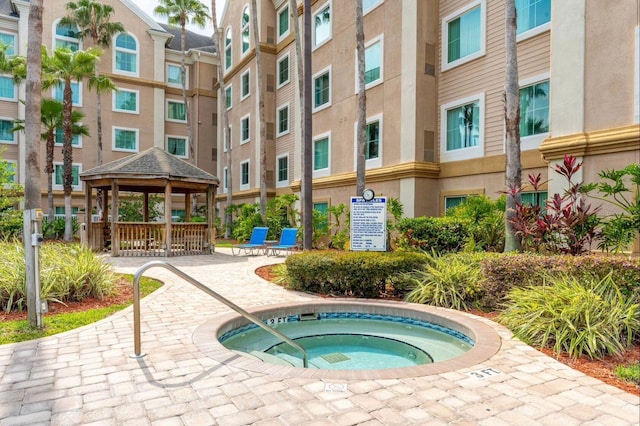 view of swimming pool with a gazebo and a hot tub