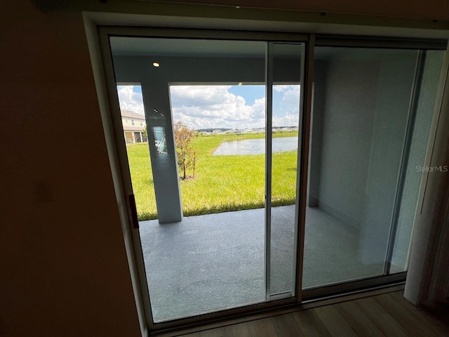 doorway to outside with wood-type flooring and a water view