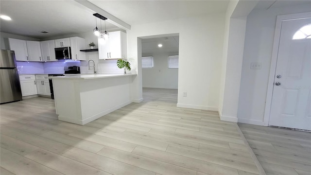 kitchen featuring kitchen peninsula, backsplash, stainless steel appliances, light hardwood / wood-style flooring, and white cabinetry