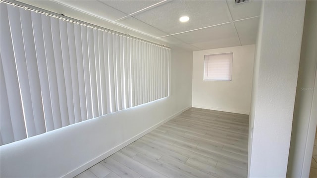 interior space with light hardwood / wood-style floors and a drop ceiling