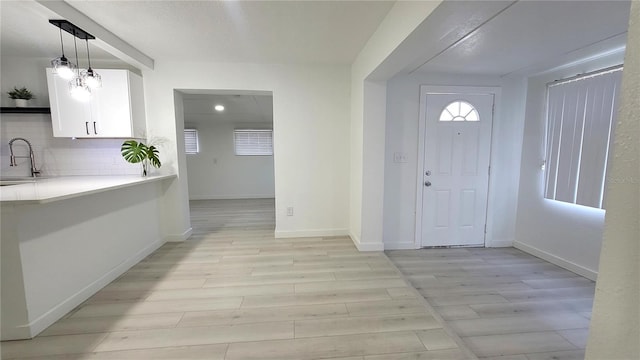 foyer entrance featuring sink and light hardwood / wood-style floors