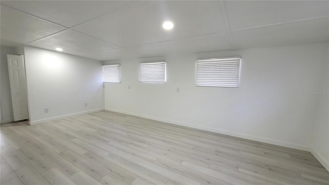 unfurnished room with a paneled ceiling and light hardwood / wood-style flooring