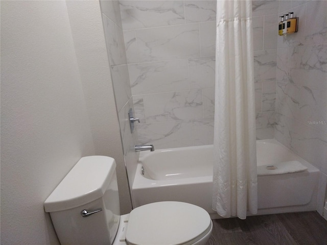 bathroom featuring toilet, hardwood / wood-style floors, and shower / tub combo