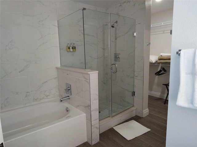 bathroom featuring plus walk in shower and hardwood / wood-style flooring