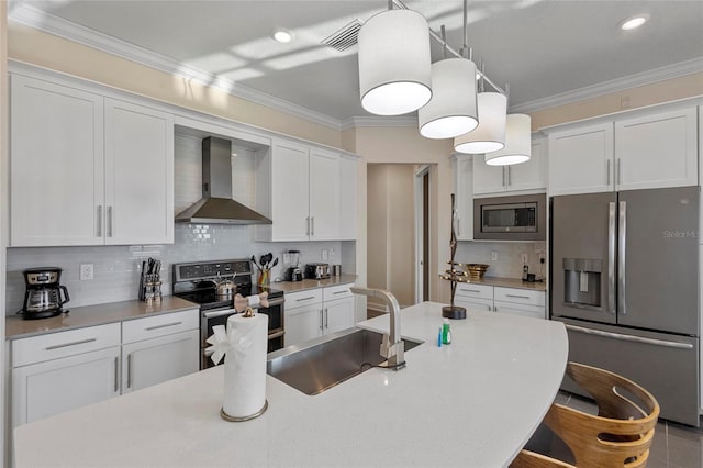 kitchen featuring appliances with stainless steel finishes, pendant lighting, backsplash, and wall chimney range hood