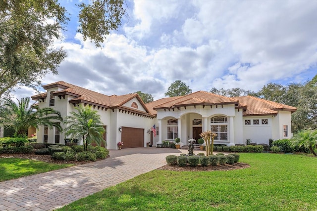 mediterranean / spanish-style house featuring a garage and a front yard