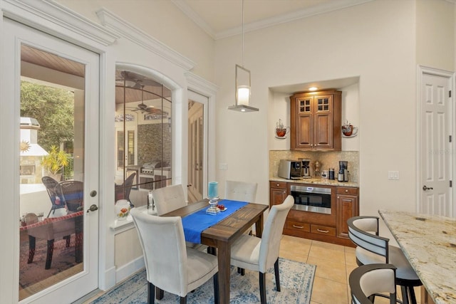 tiled dining space featuring crown molding