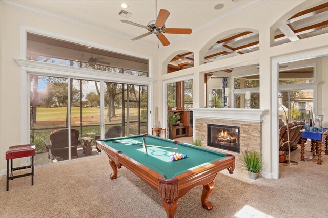 recreation room with ceiling fan, billiards, carpet, crown molding, and a stone fireplace