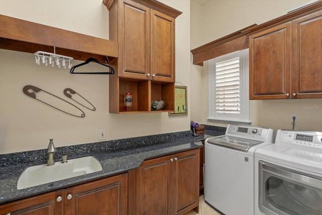 laundry room featuring cabinets, washer and clothes dryer, and sink