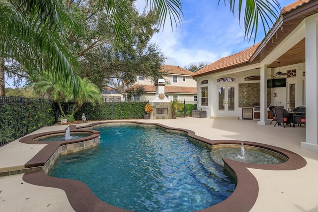 view of swimming pool featuring ceiling fan, an in ground hot tub, an outdoor fireplace, french doors, and a patio