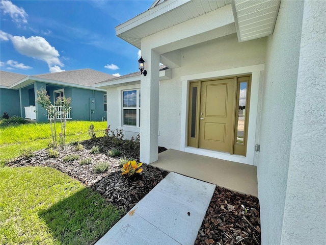 entrance to property featuring a lawn