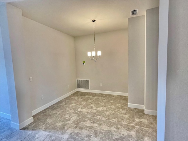 empty room featuring light tile flooring and a chandelier