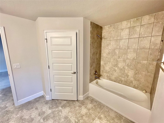 bathroom featuring tiled shower / bath combo, a textured ceiling, and tile flooring