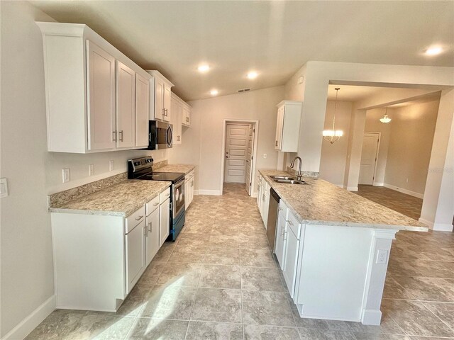 kitchen with pendant lighting, white cabinets, appliances with stainless steel finishes, and light tile floors