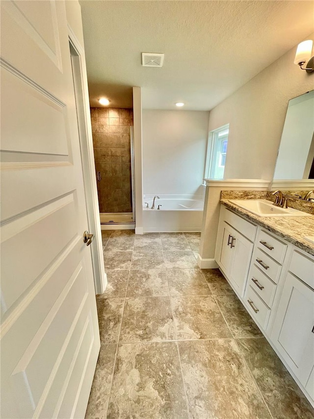 bathroom featuring a textured ceiling, vanity, independent shower and bath, and tile flooring