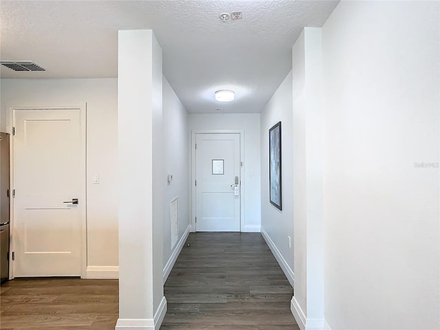 corridor featuring dark hardwood / wood-style floors and a textured ceiling